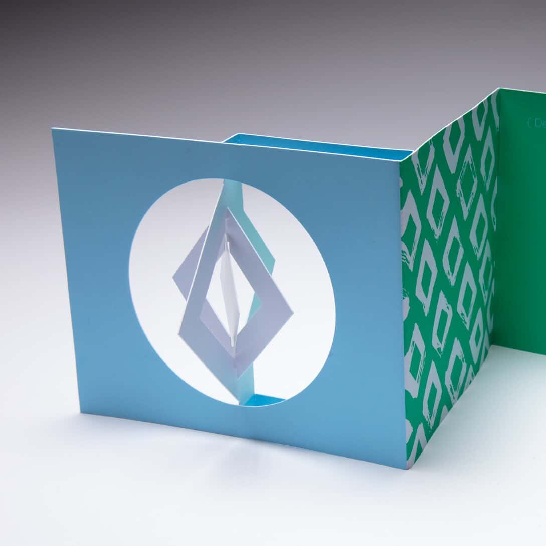 Designers use the Diamond Spinner Holiday Card to send a greeting to their clients
